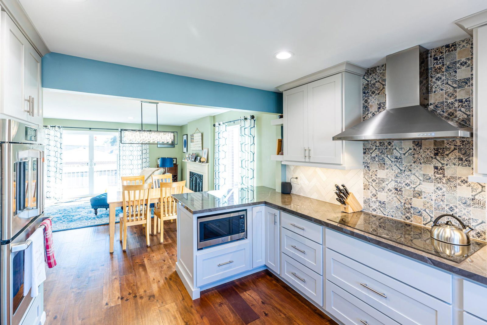 A kitchen with a stove top oven next to a dining room table