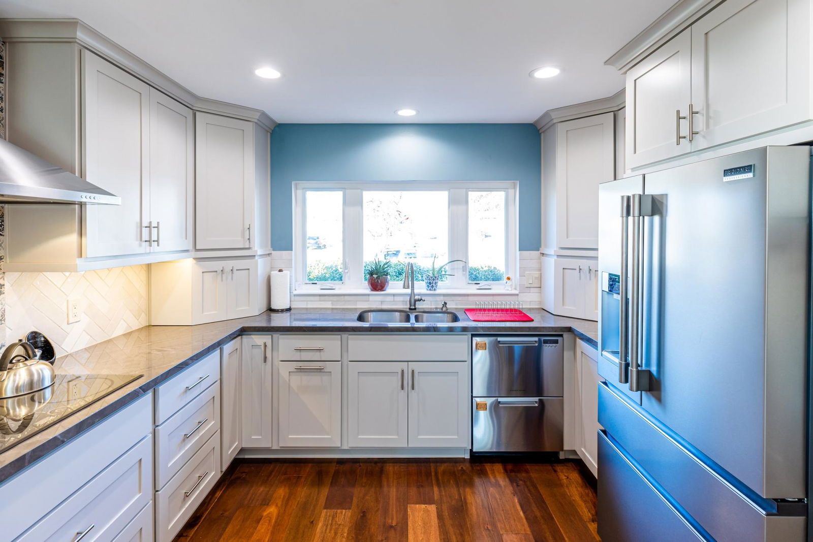 A kitchen with white cabinets and blue walls