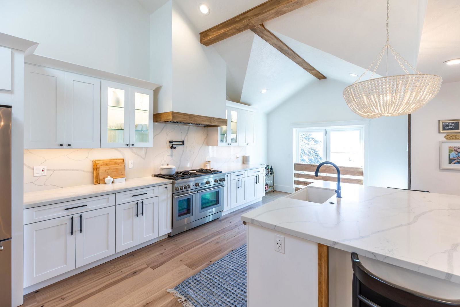 A kitchen with a stove, sink, and refrigerator