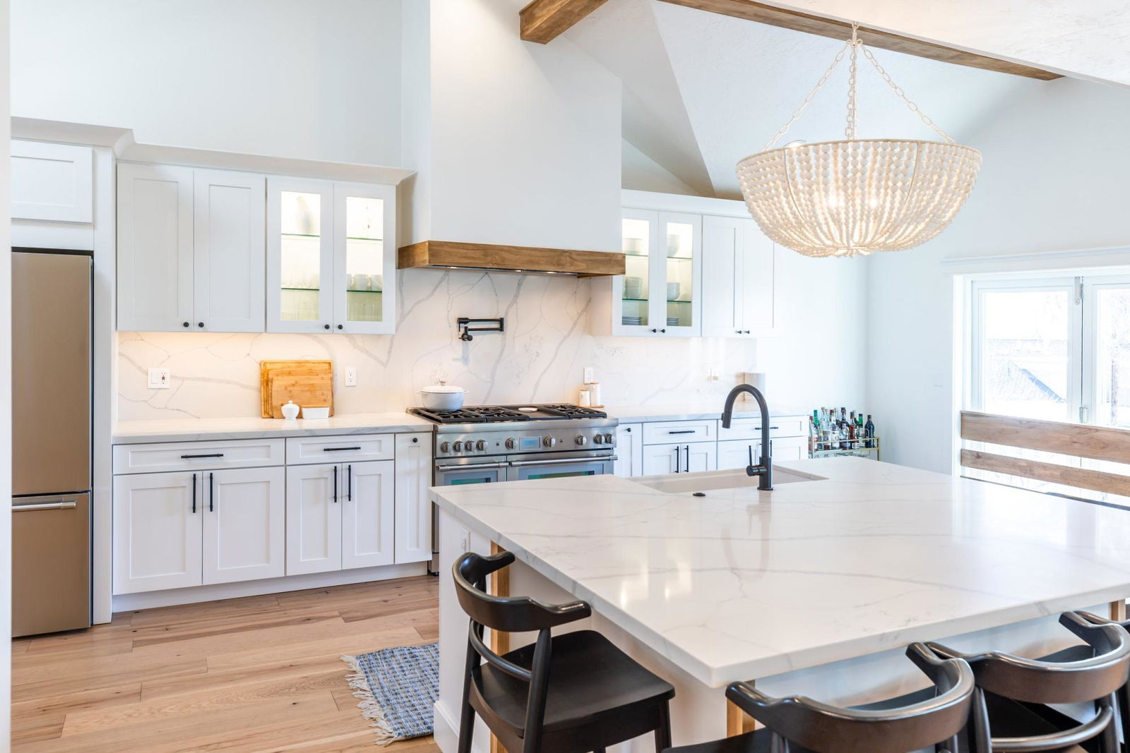 A kitchen with a center island and a chandelier hanging above it.