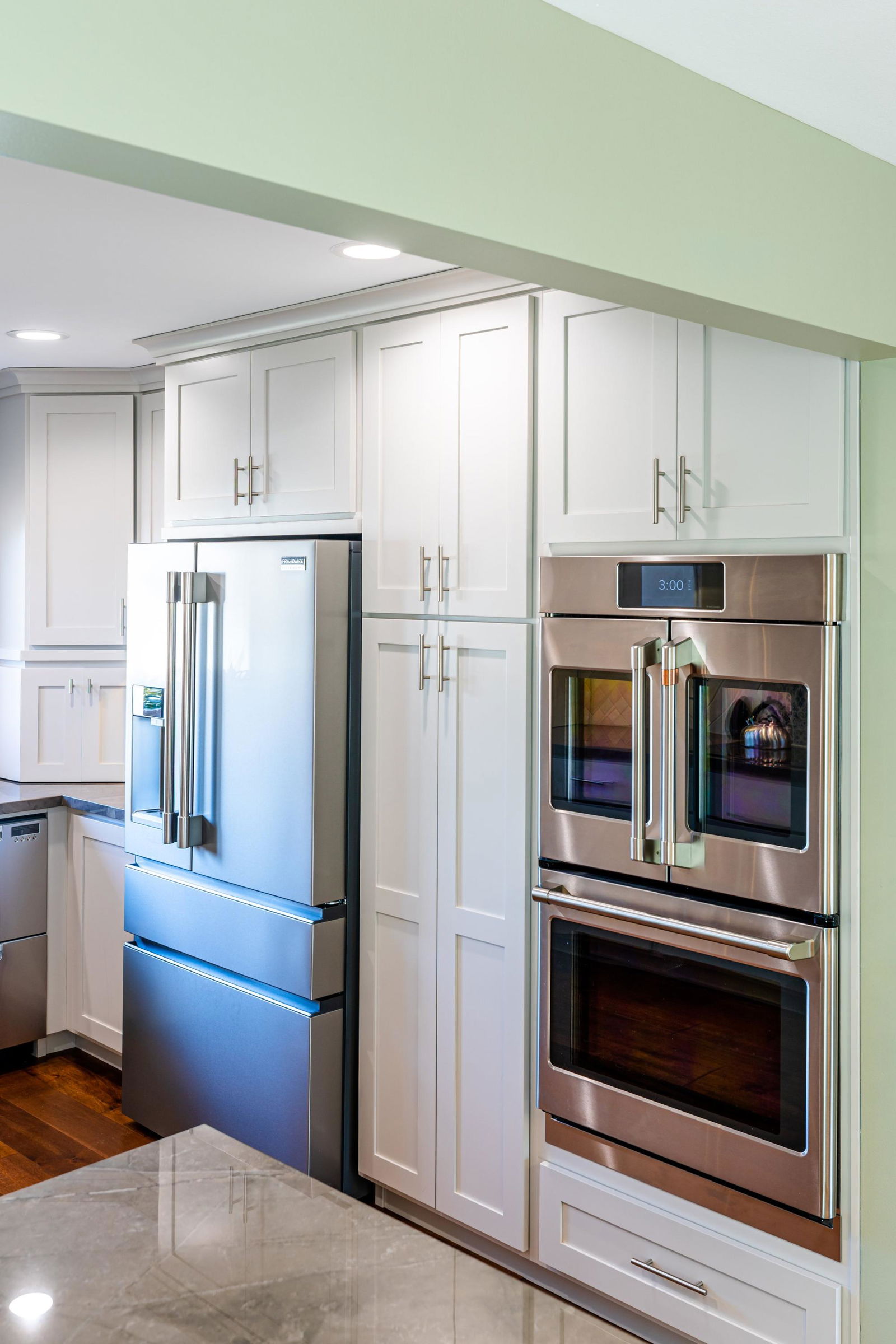 A kitchen with stainless steel appliances including a refrigerator, oven, and microwave.