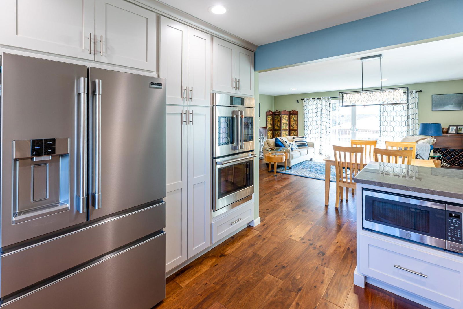 A kitchen with a stainless steel refrigerator, stove, and microwave.