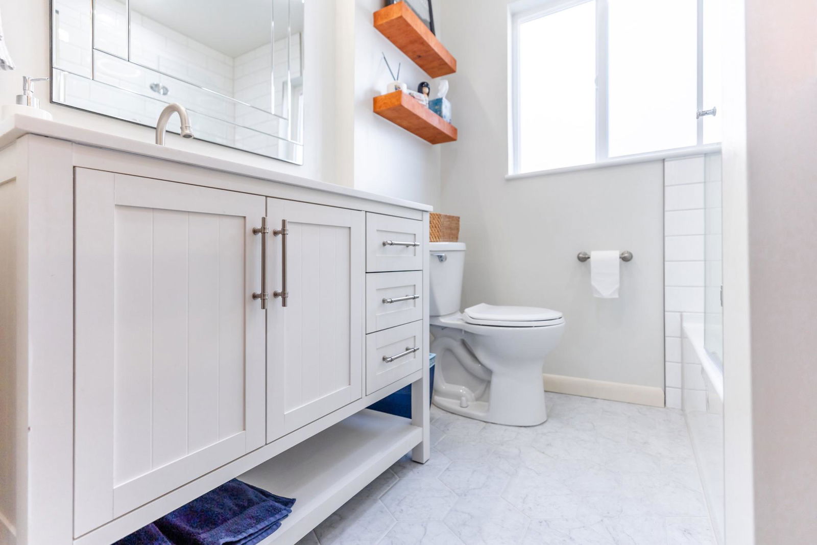 A bathroom with a toilet, sink, and mirror