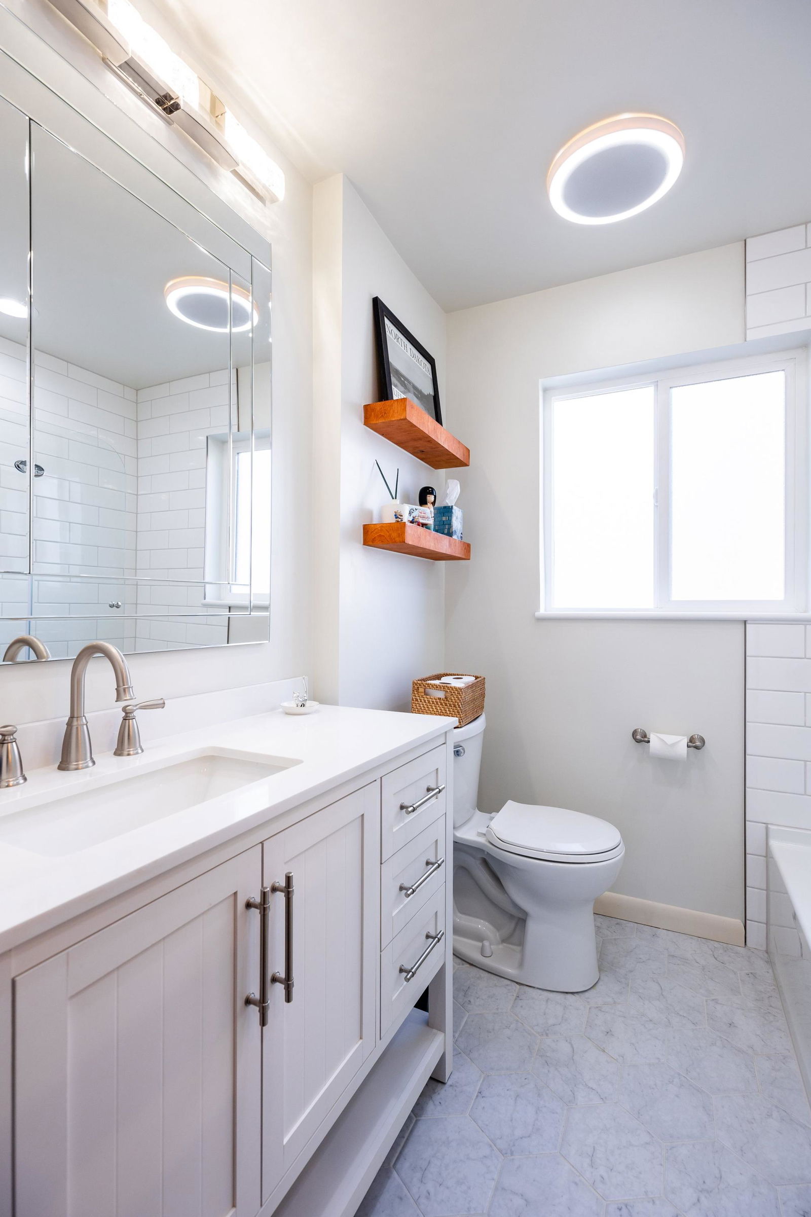 A bathroom with a toilet, sink, and mirror