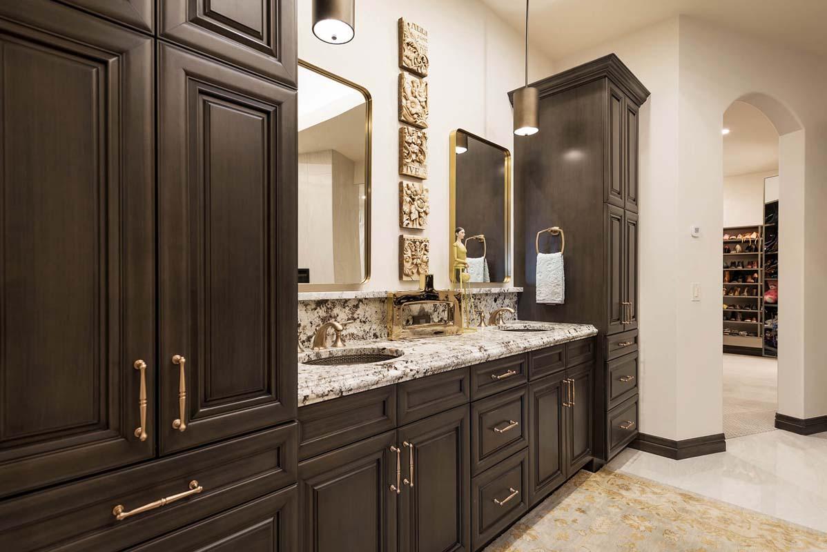 A bathroom with a double sink and brown cabinets