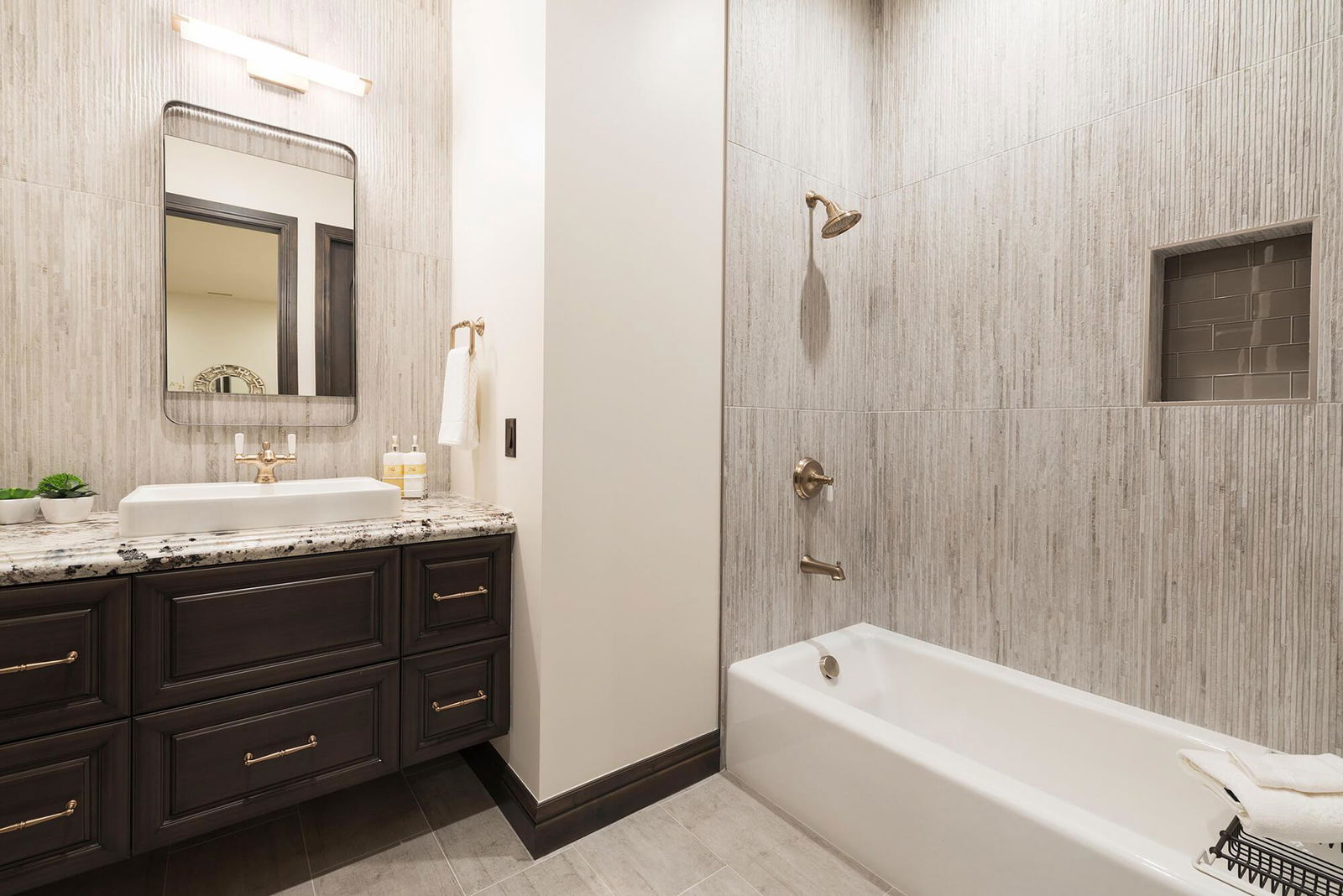 A bathroom with a sink, mirror, and bathtub