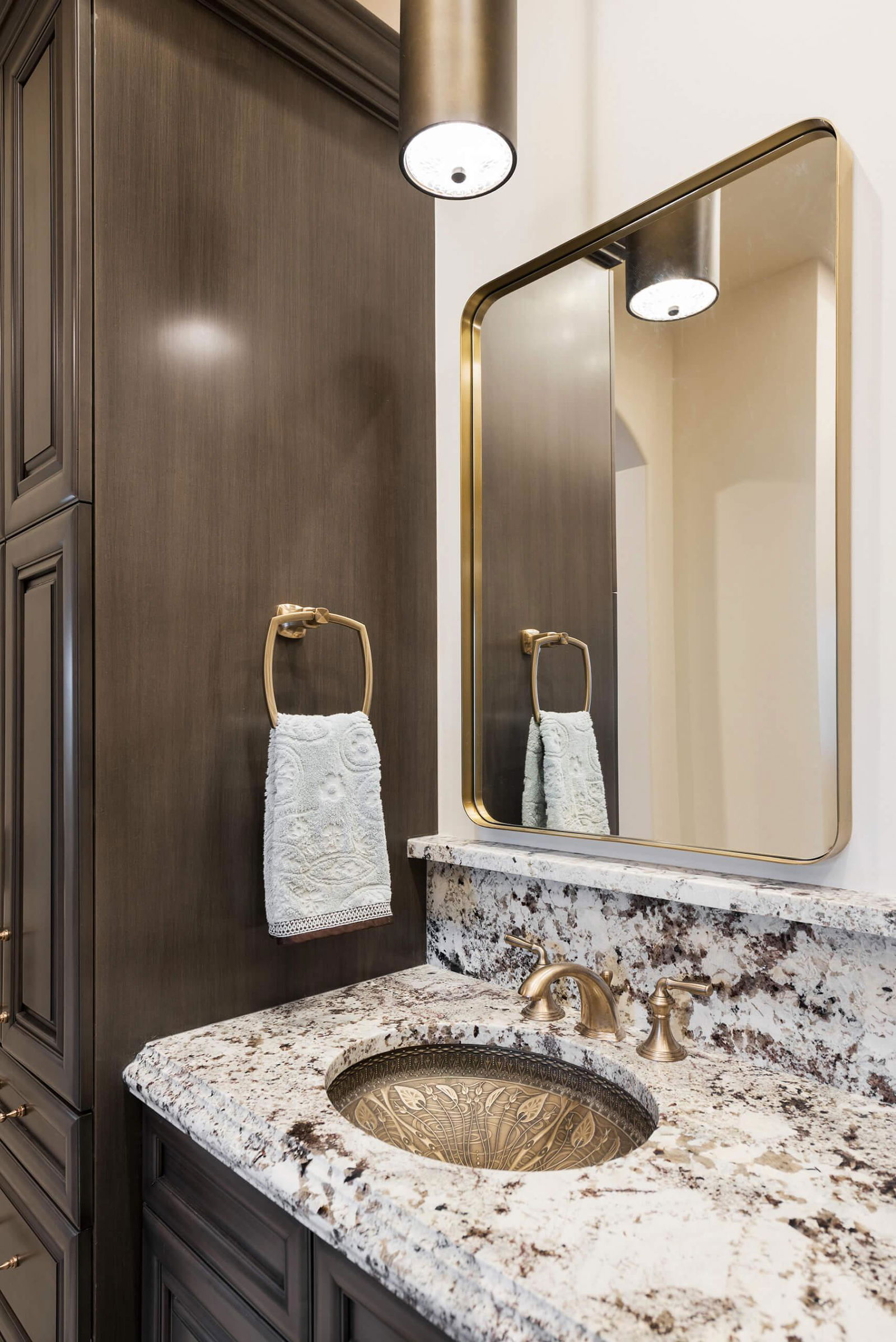 A bathroom with a marble sink and a large mirror