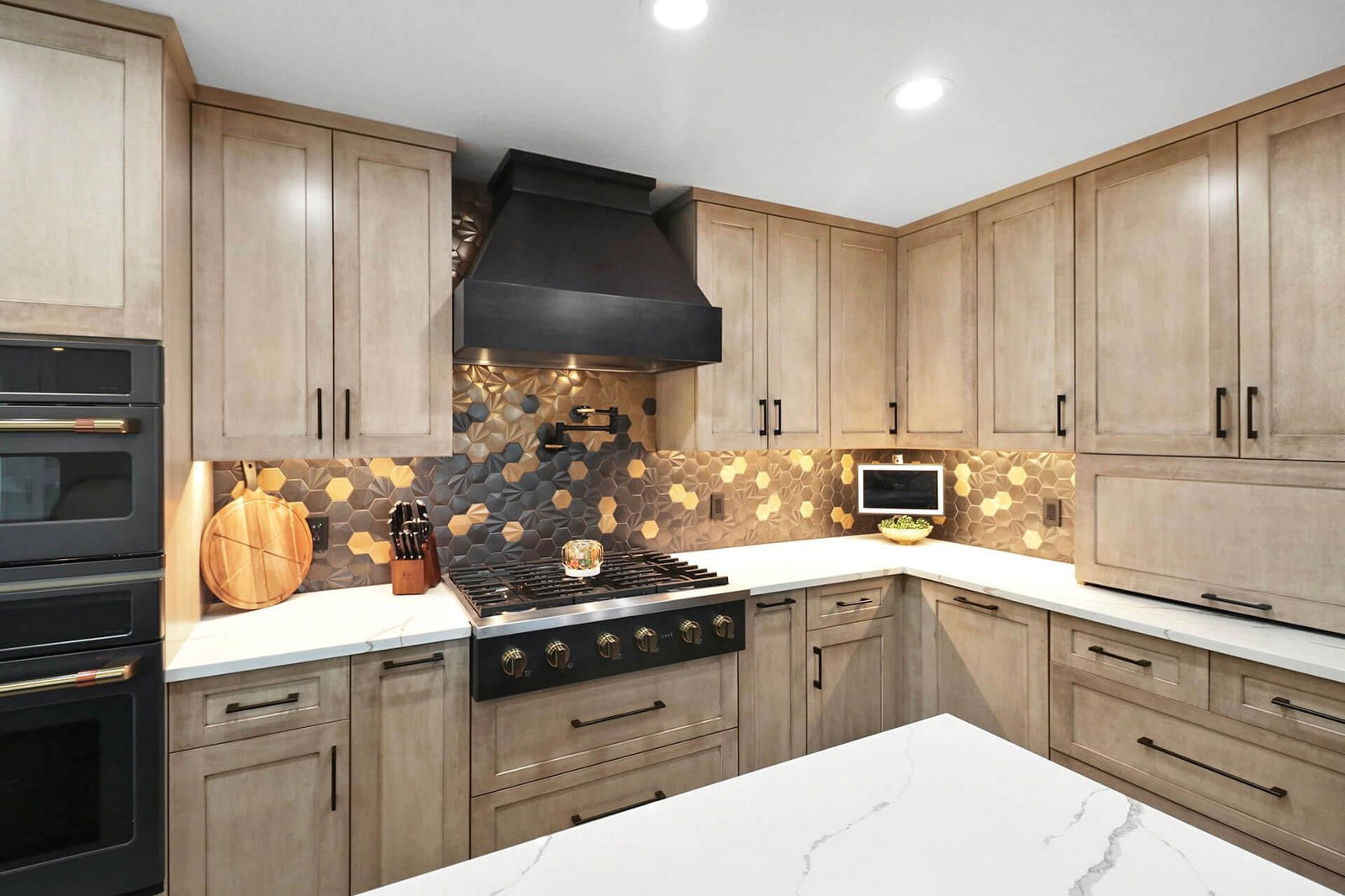 A kitchen with marble counter tops and wooden cabinets