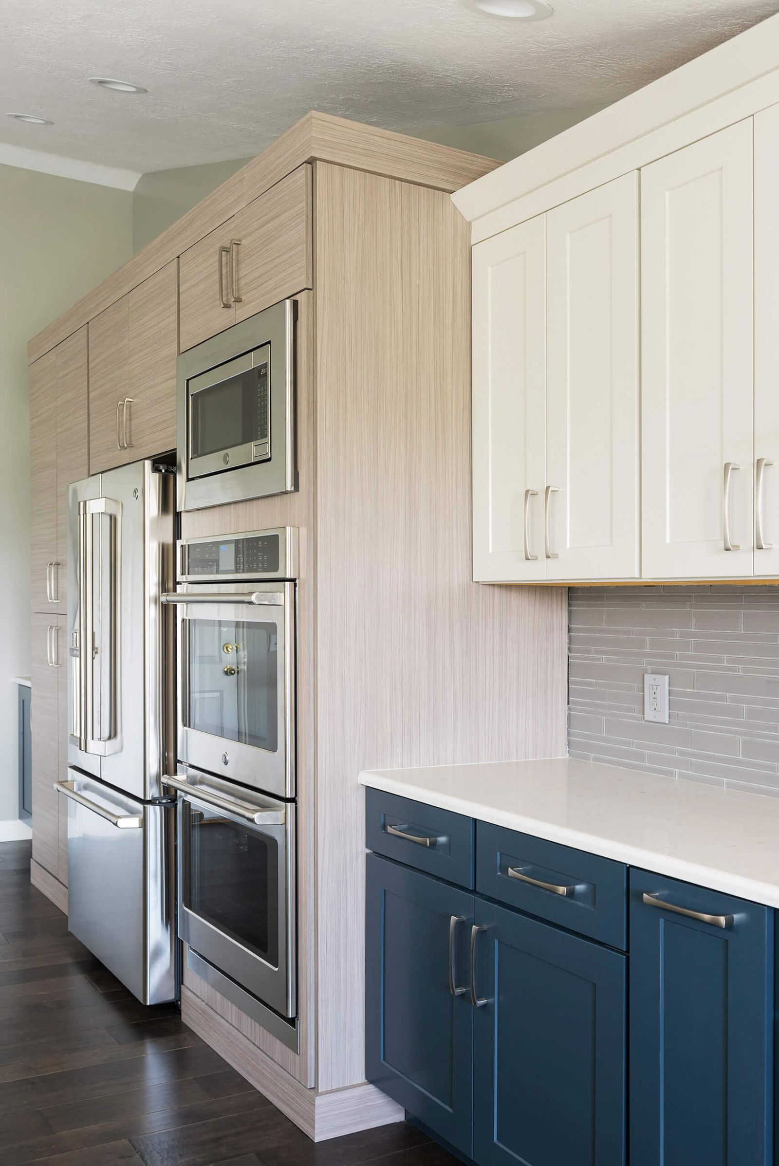 A kitchen with blue cabinets and a stainless steel oven