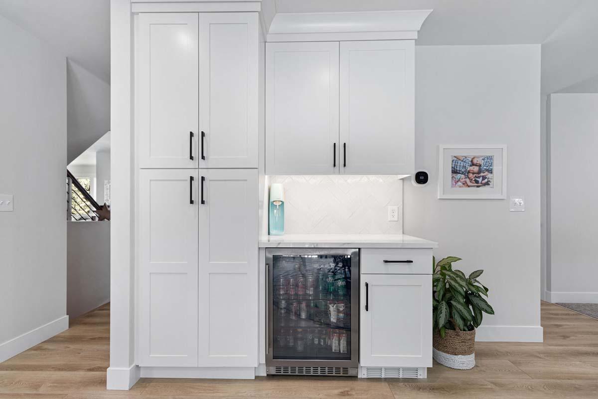 A kitchen with white cabinets and a refrigerator