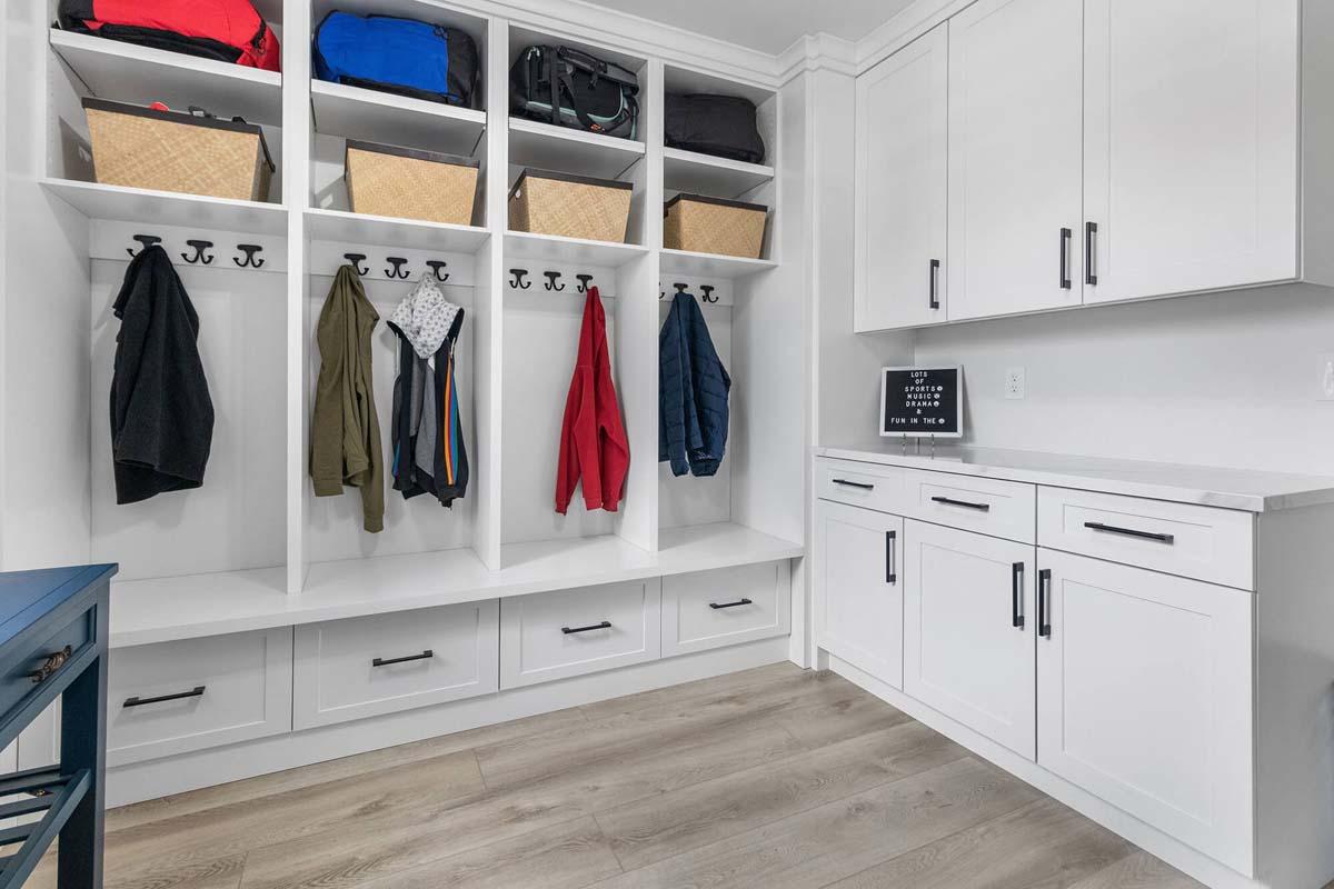 A white closet with a bunch of coats hanging on it