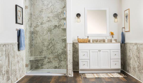 A bathroom with a walk in shower next to a sink