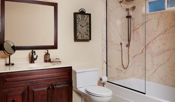 A bathroom with a sink, mirror, toilet and shower