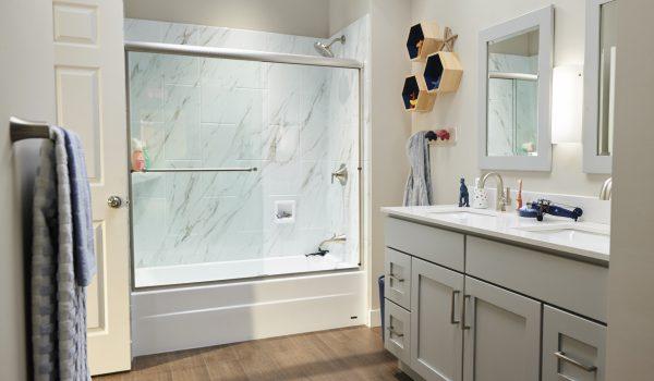 A bathroom with a shower, sink, and mirror