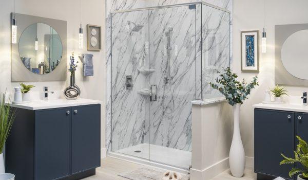 A bathroom with a walk in shower next to two sinks