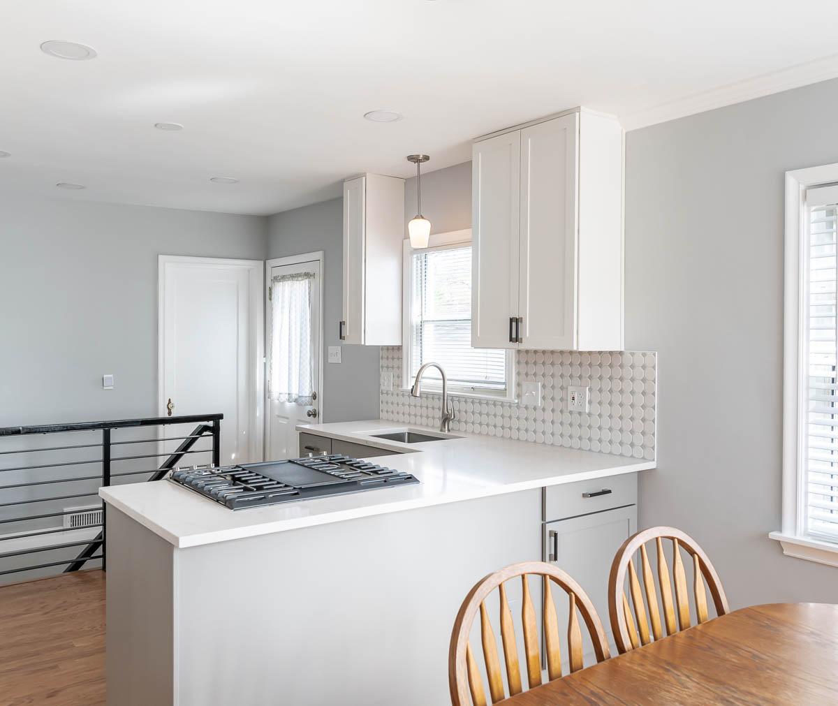 A kitchen with a stove top oven next to a dining room table