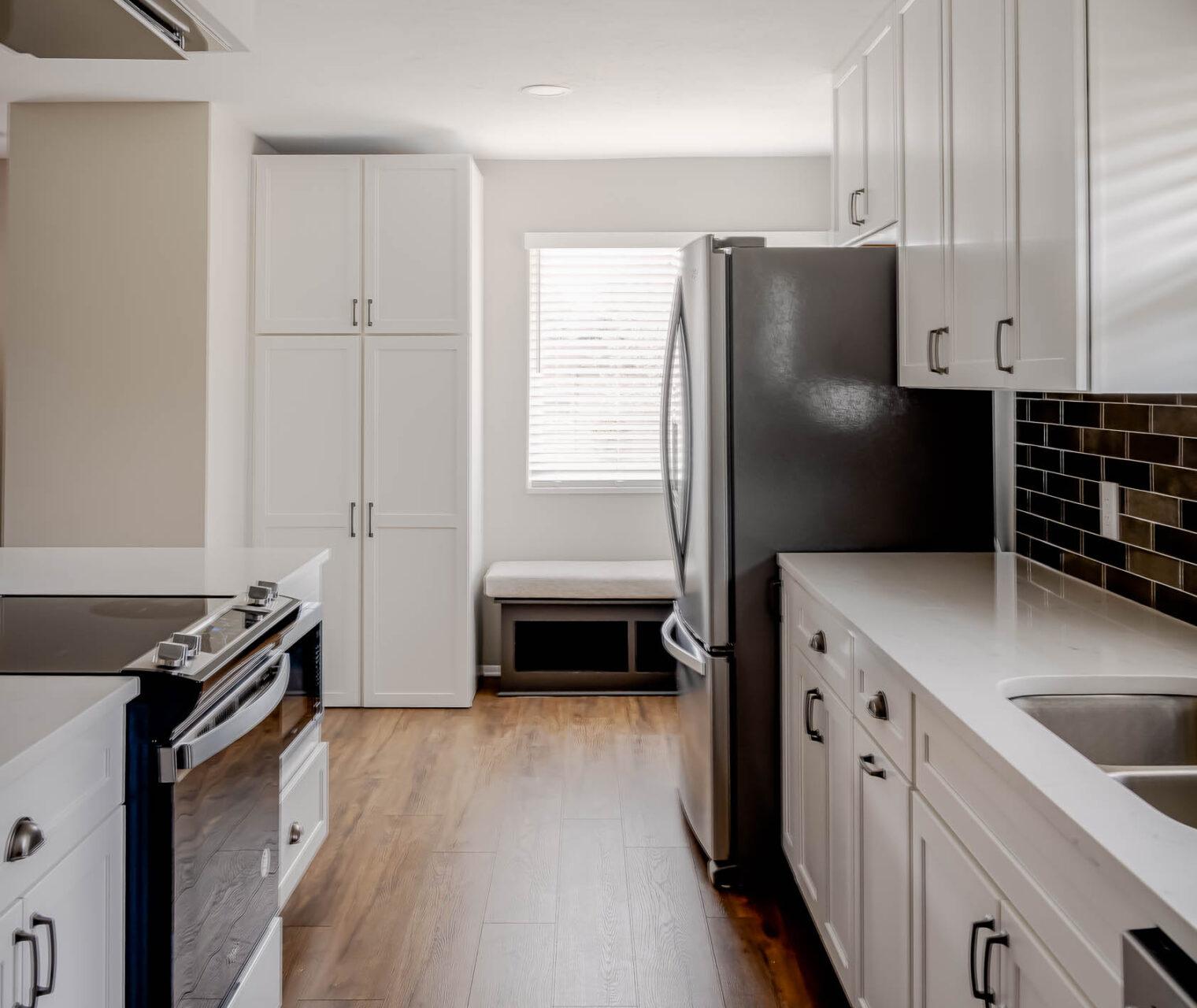 A kitchen with white cabinets and black appliances