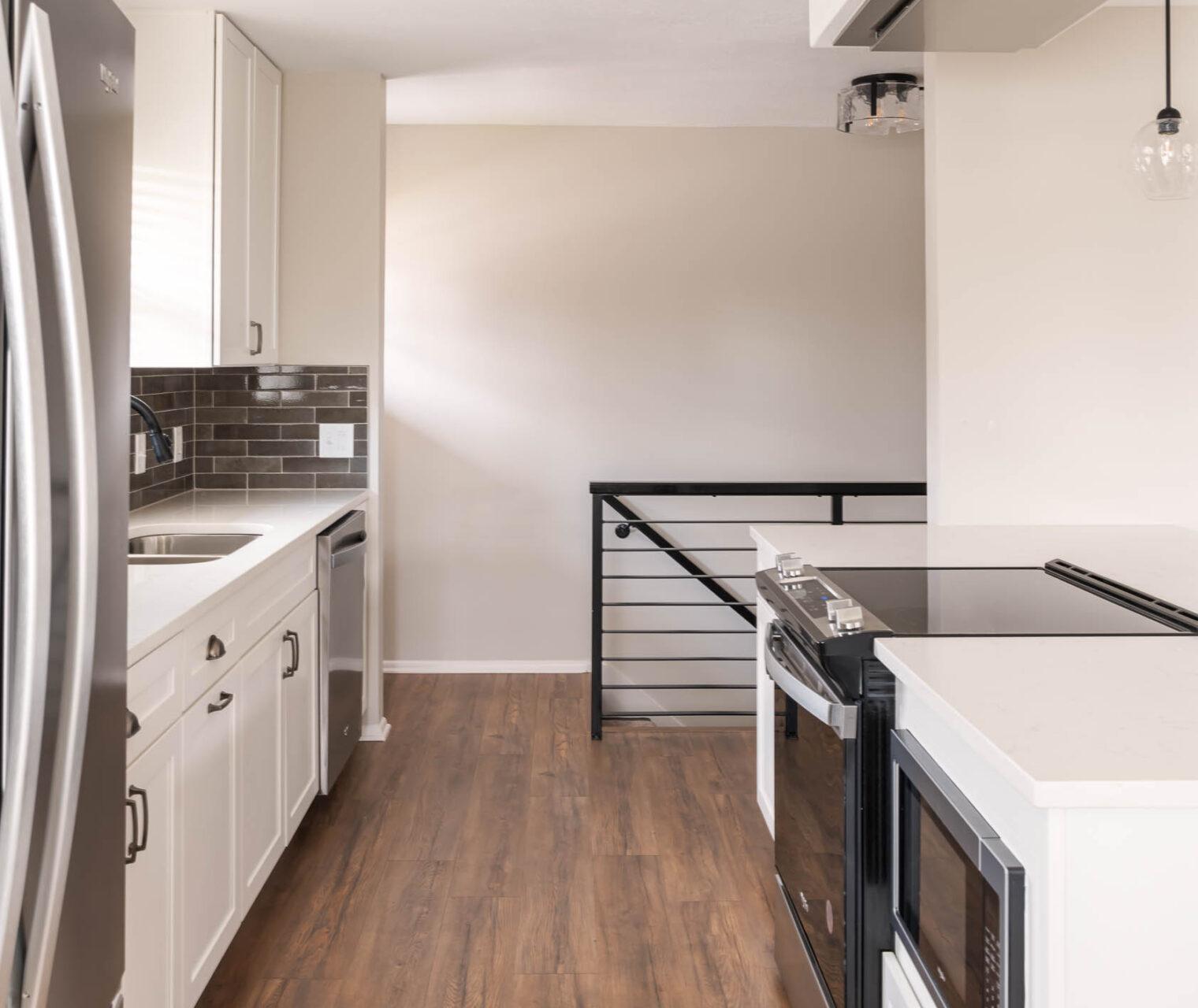 A kitchen with a refrigerator, stove, and sink