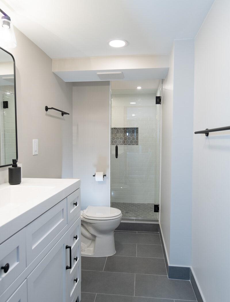 A bathroom with a walk in shower next to a toilet