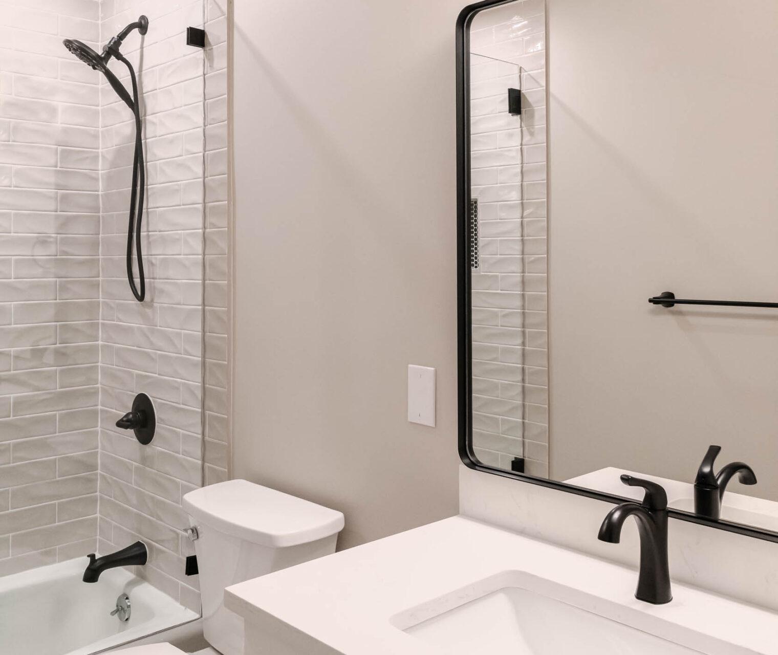 A bathroom with a sink, mirror, toilet and bathtub