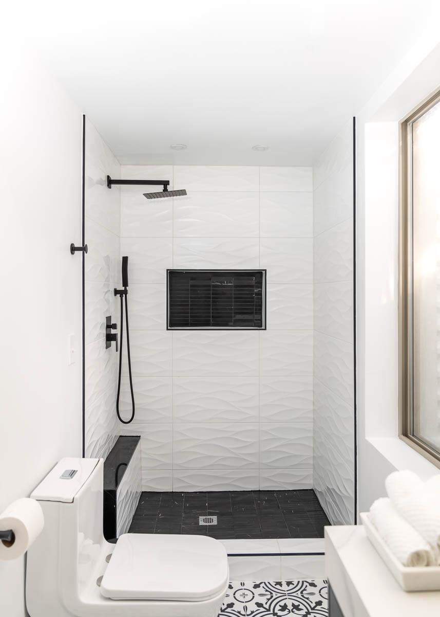 A black and white bathroom with a walk in shower