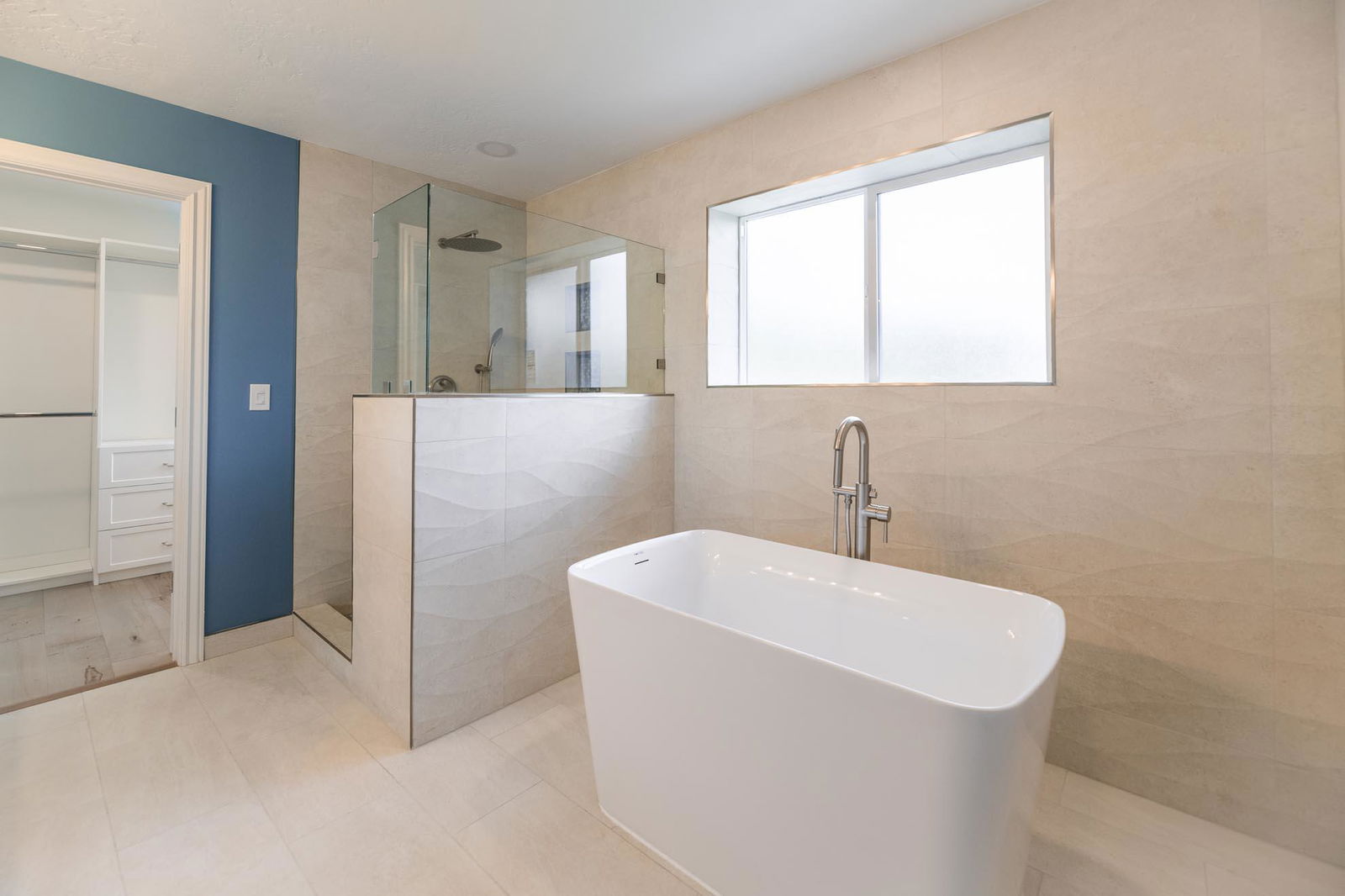 A large white bath tub sitting next to a walk in shower