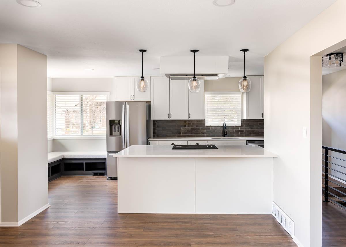 A kitchen with a refrigerator and a stove top oven