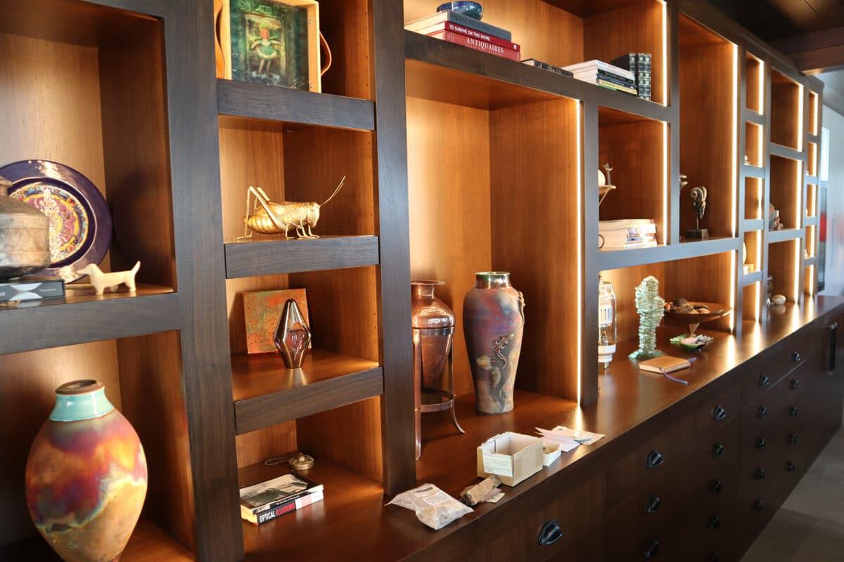 A wooden shelf filled with vases and other decorative items