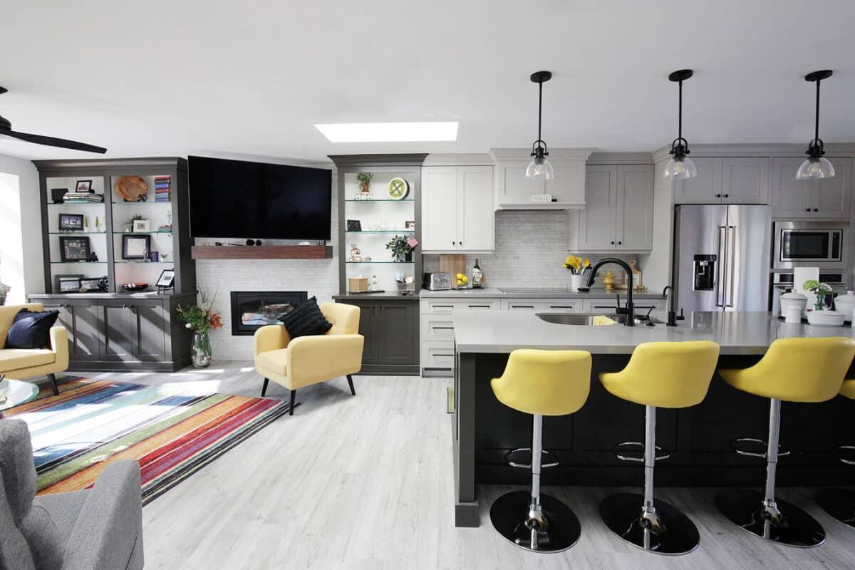 A kitchen with a center island and yellow chairs