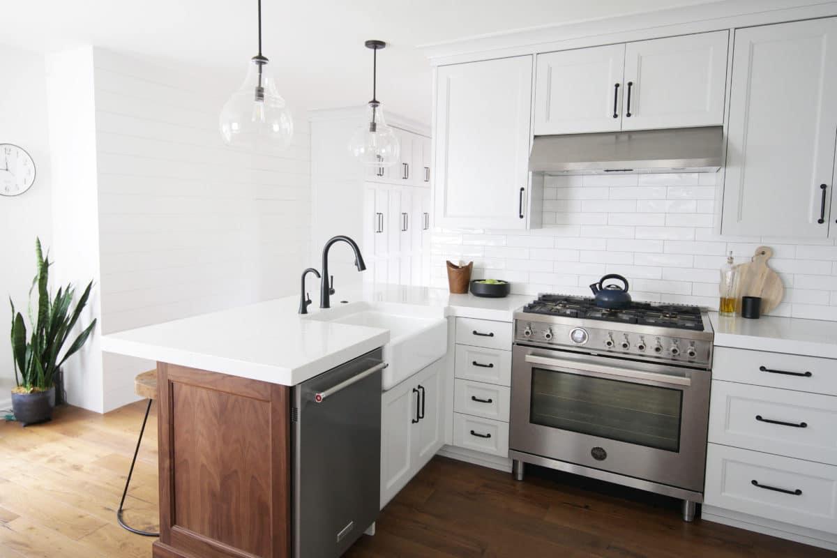 A kitchen with white cabinets and a stainless steel stove