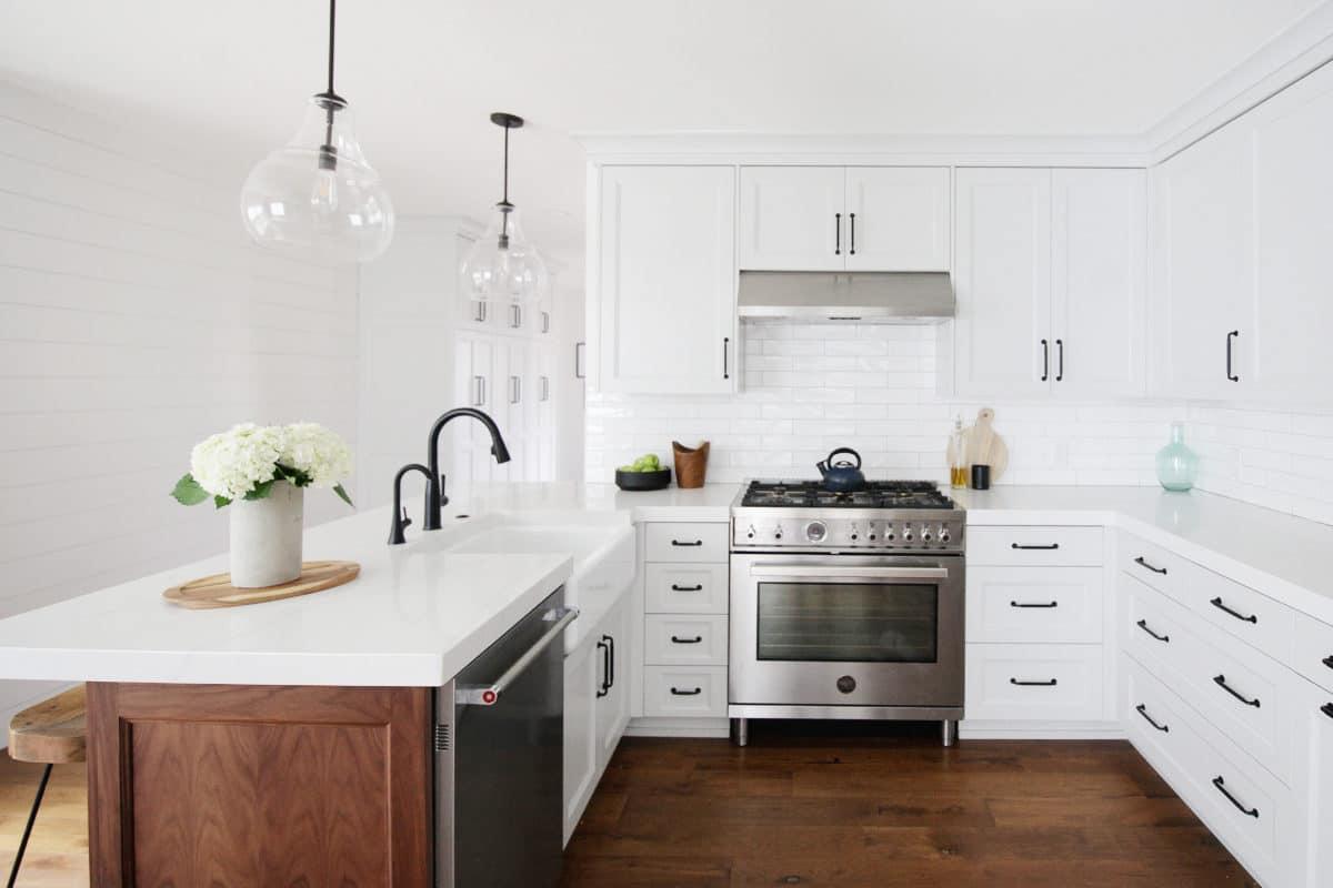 A kitchen with white cabinets and a stainless steel stove