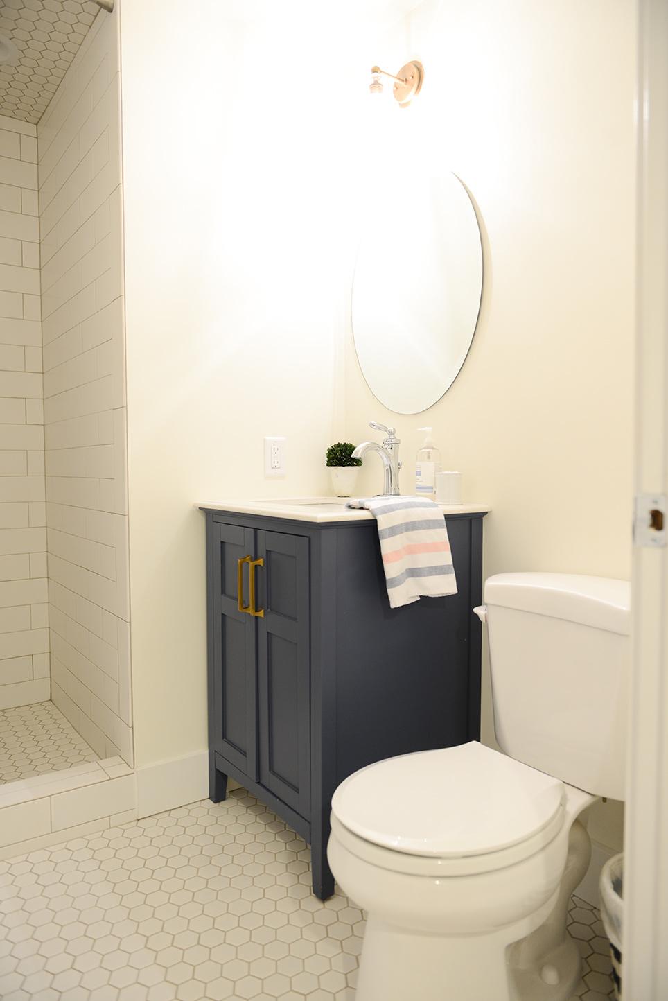 A white toilet sitting next to a blue cabinet