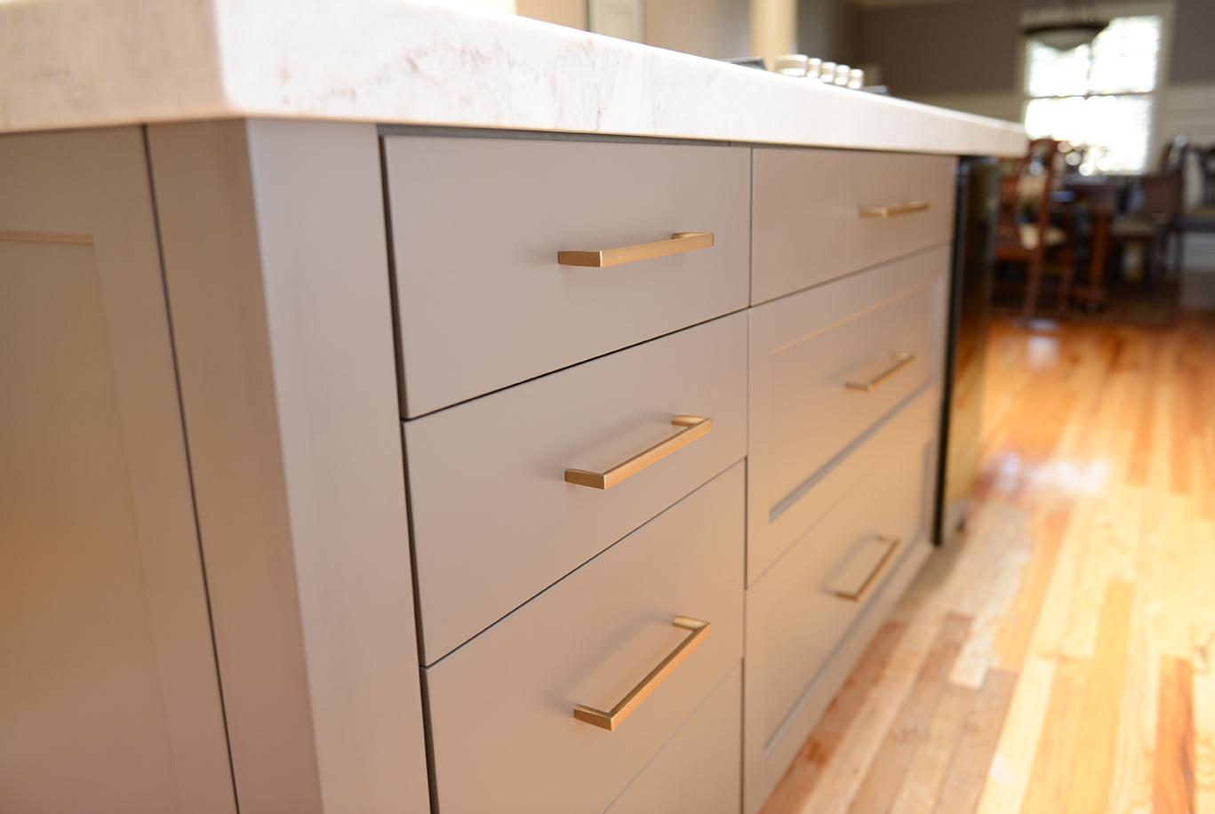 A kitchen with a wooden floor and white cabinets