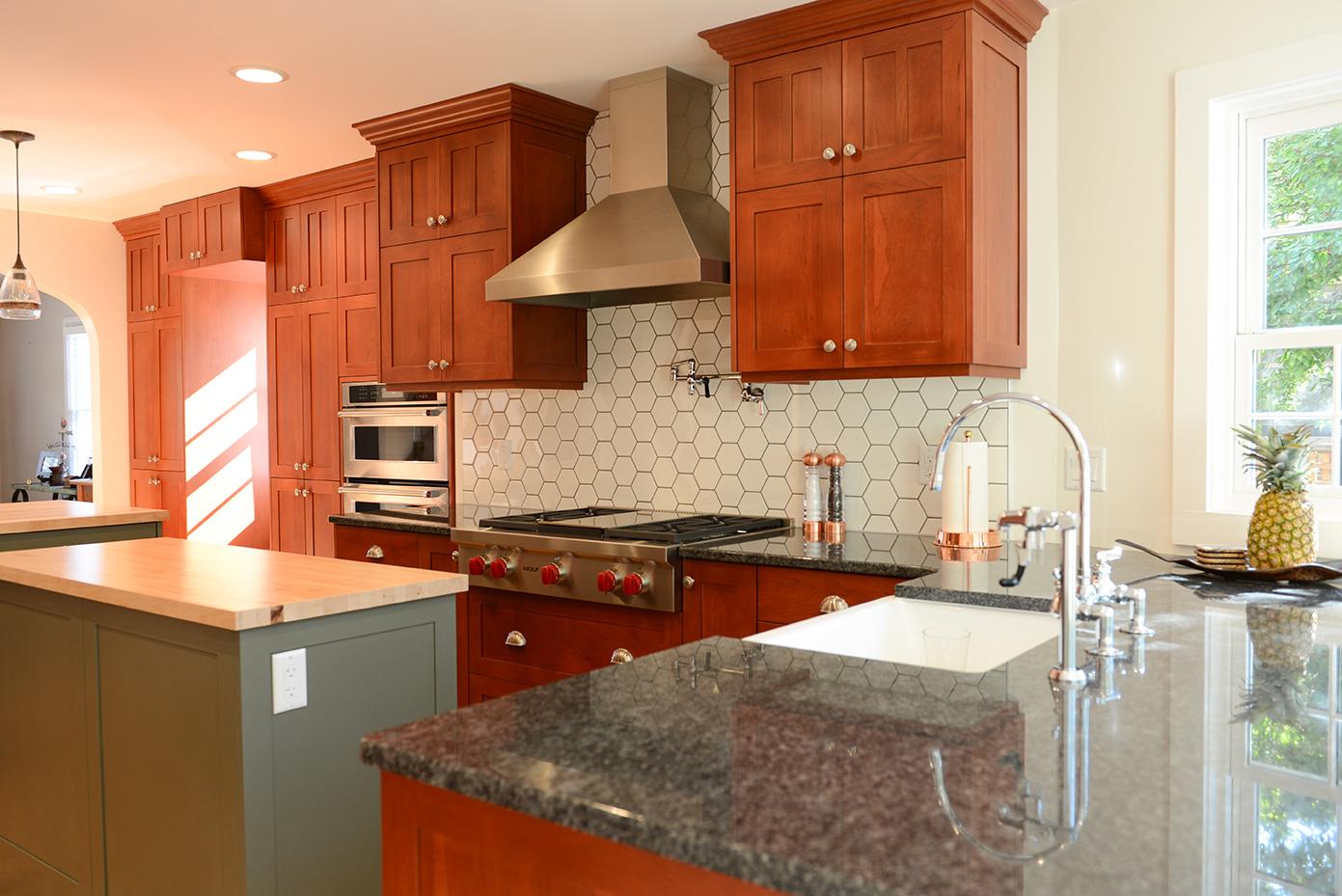 A kitchen with wooden cabinets and a marble counter top