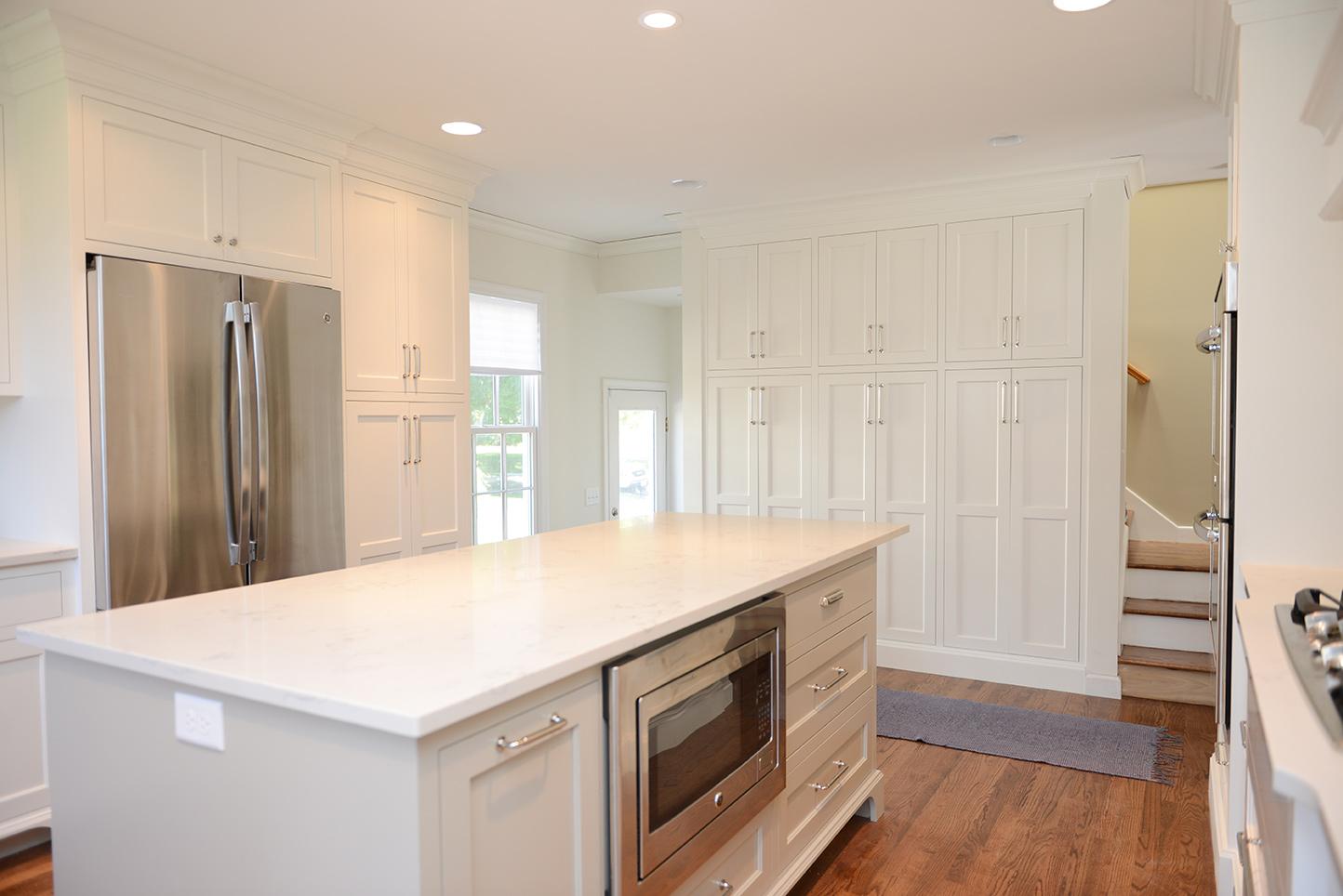 A kitchen with white cabinets and stainless steel appliances