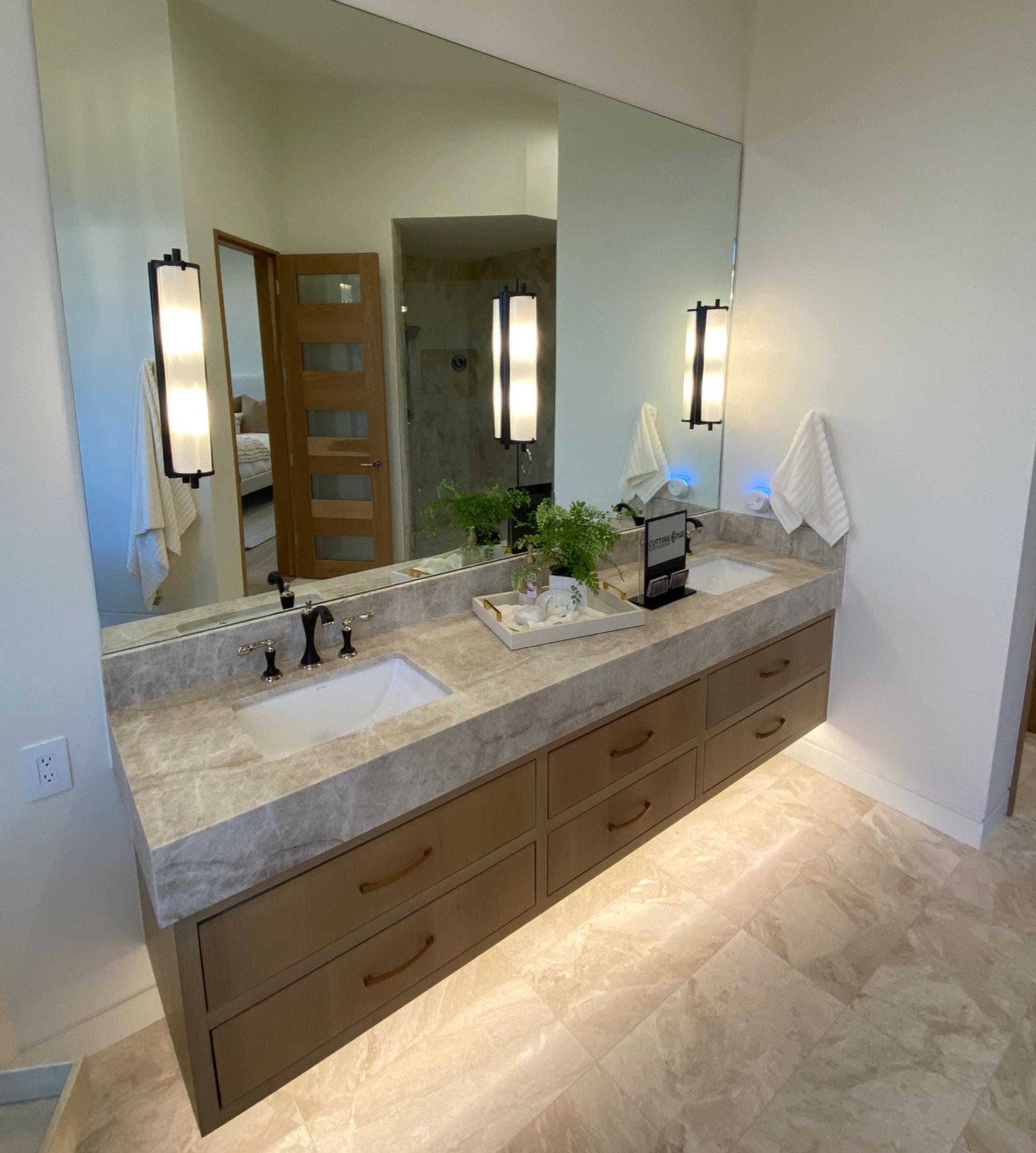 A bathroom with two sinks and a large mirror