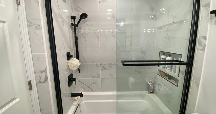 A bathroom with a glass shower door and a white toilet