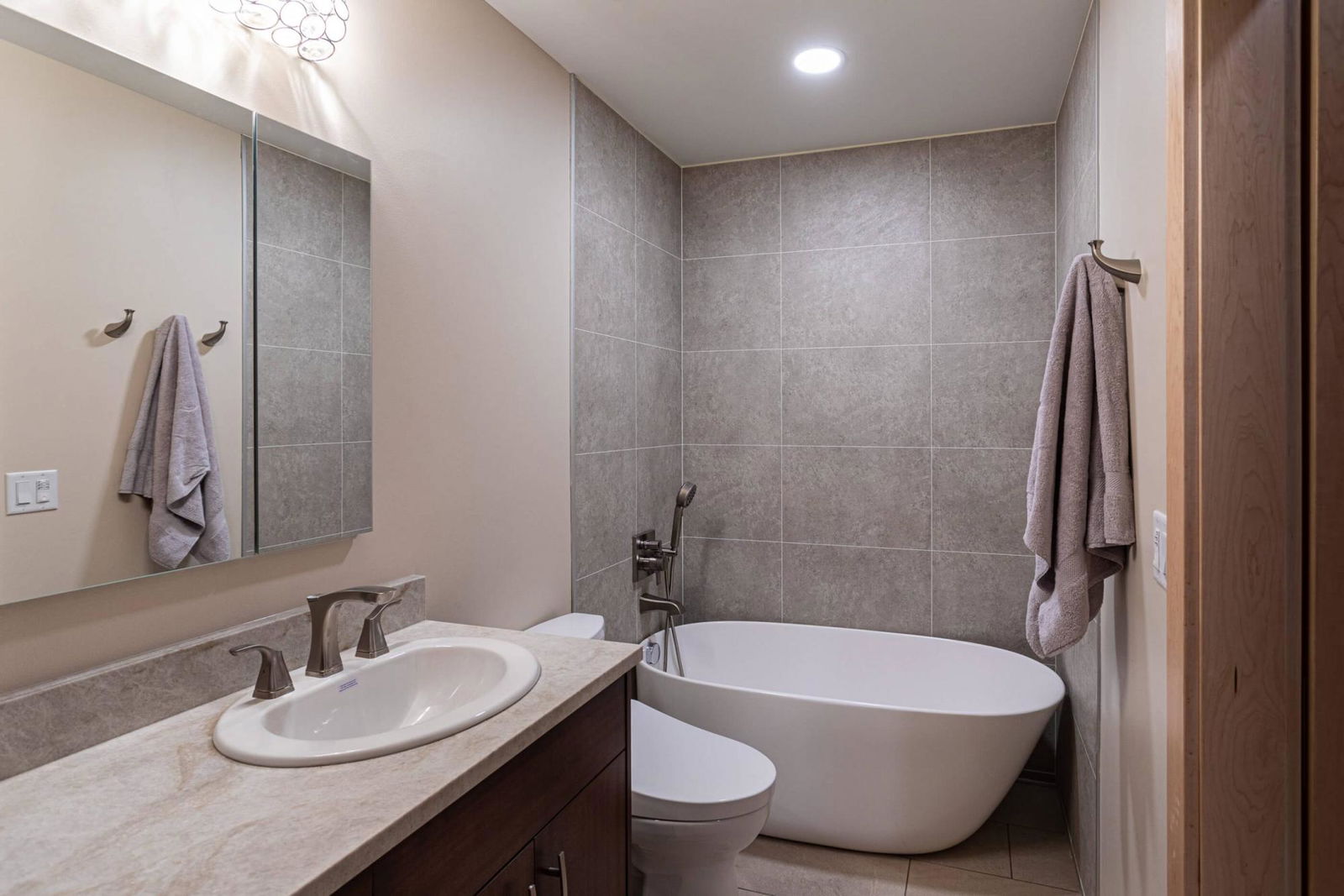 A bath room with a bath tub a sink and a mirror