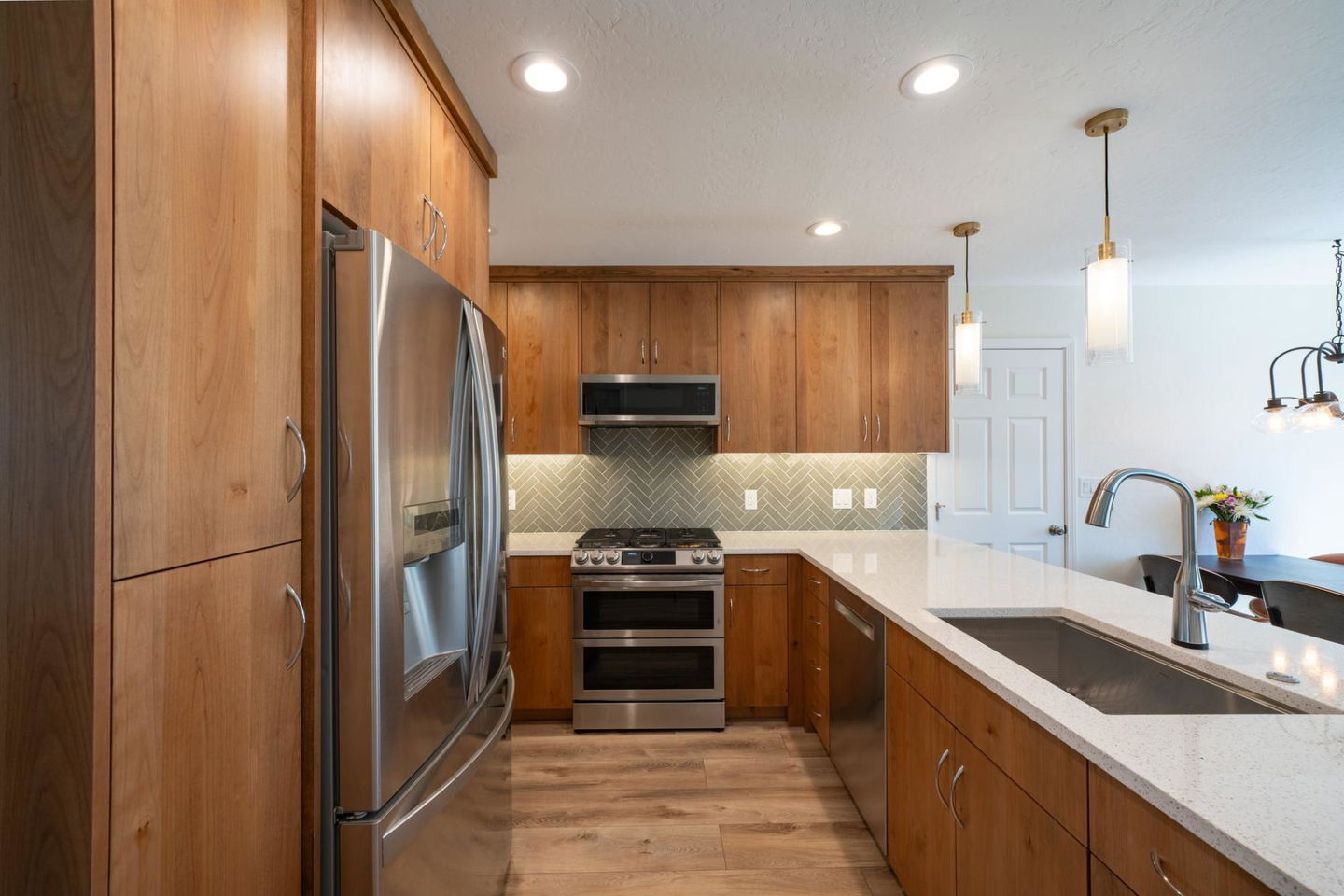 A kitchen with a stainless steel refrigerator and stove