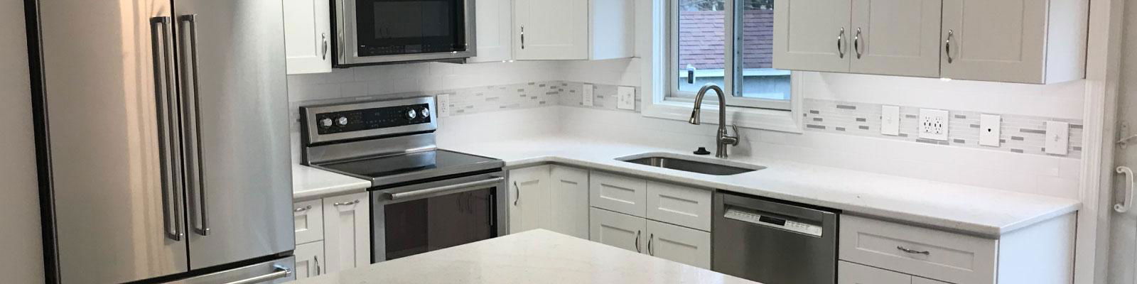 A kitchen with stainless steel appliances and white cabinets