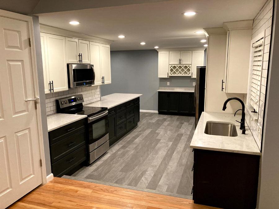 A kitchen with a sink, stove, microwave and refrigerator