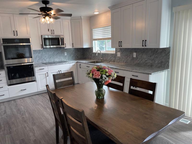 A kitchen with a wooden table and white cabinets