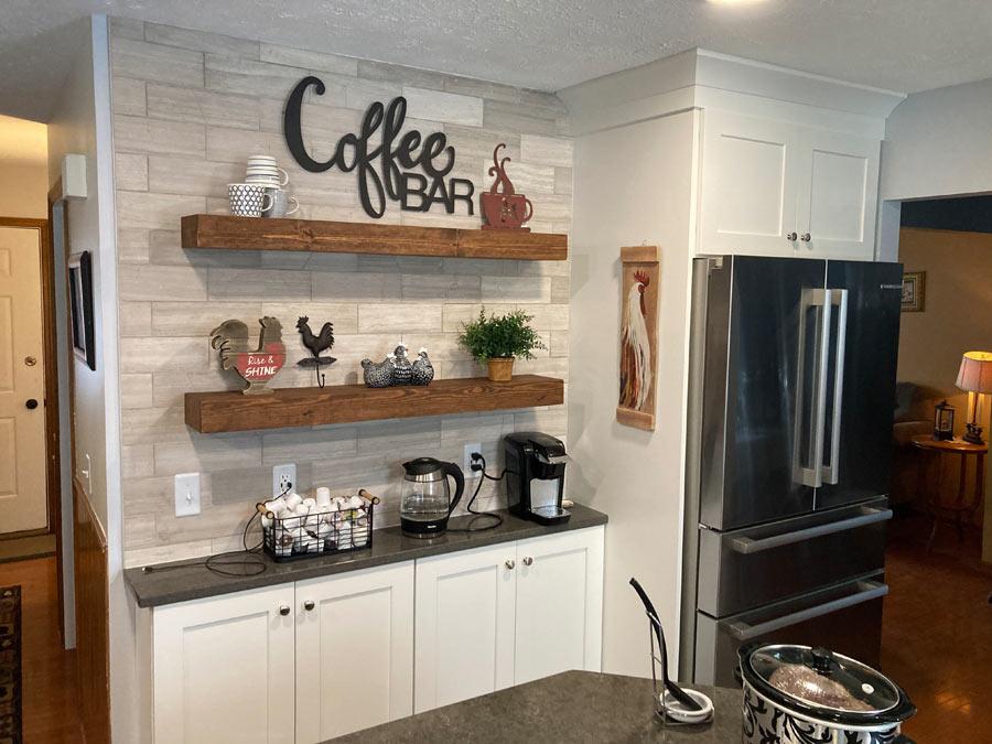 A kitchen with a coffee bar and refrigerator