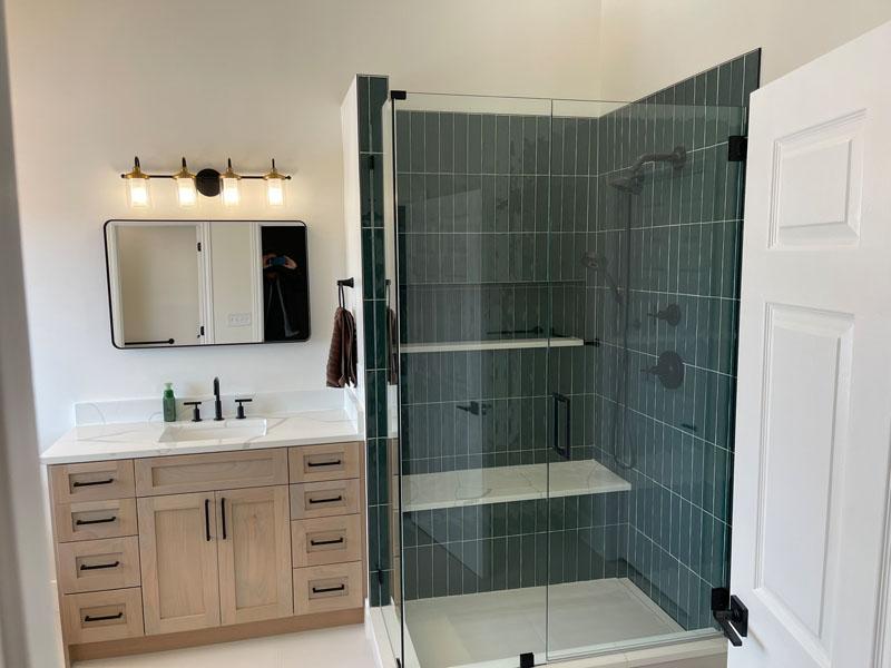 A bathroom with a walk in shower next to a sink