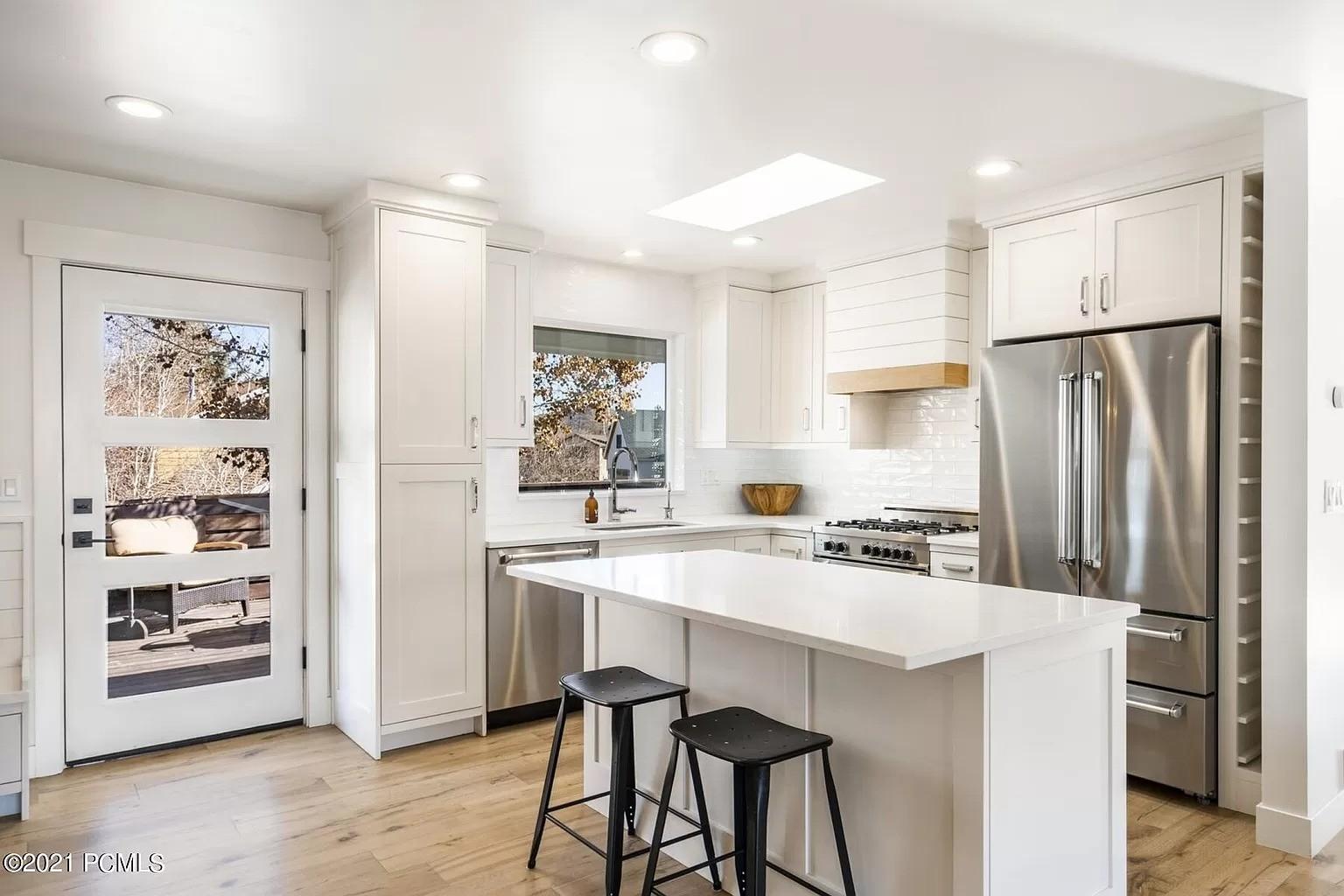 A kitchen with a center island and two stools