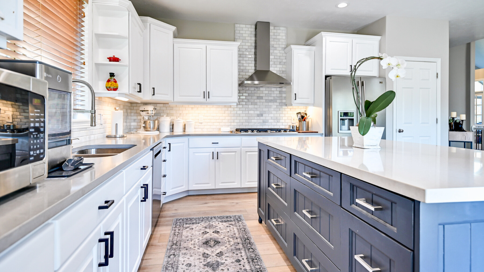 A kitchen with white cabinets and a blue island