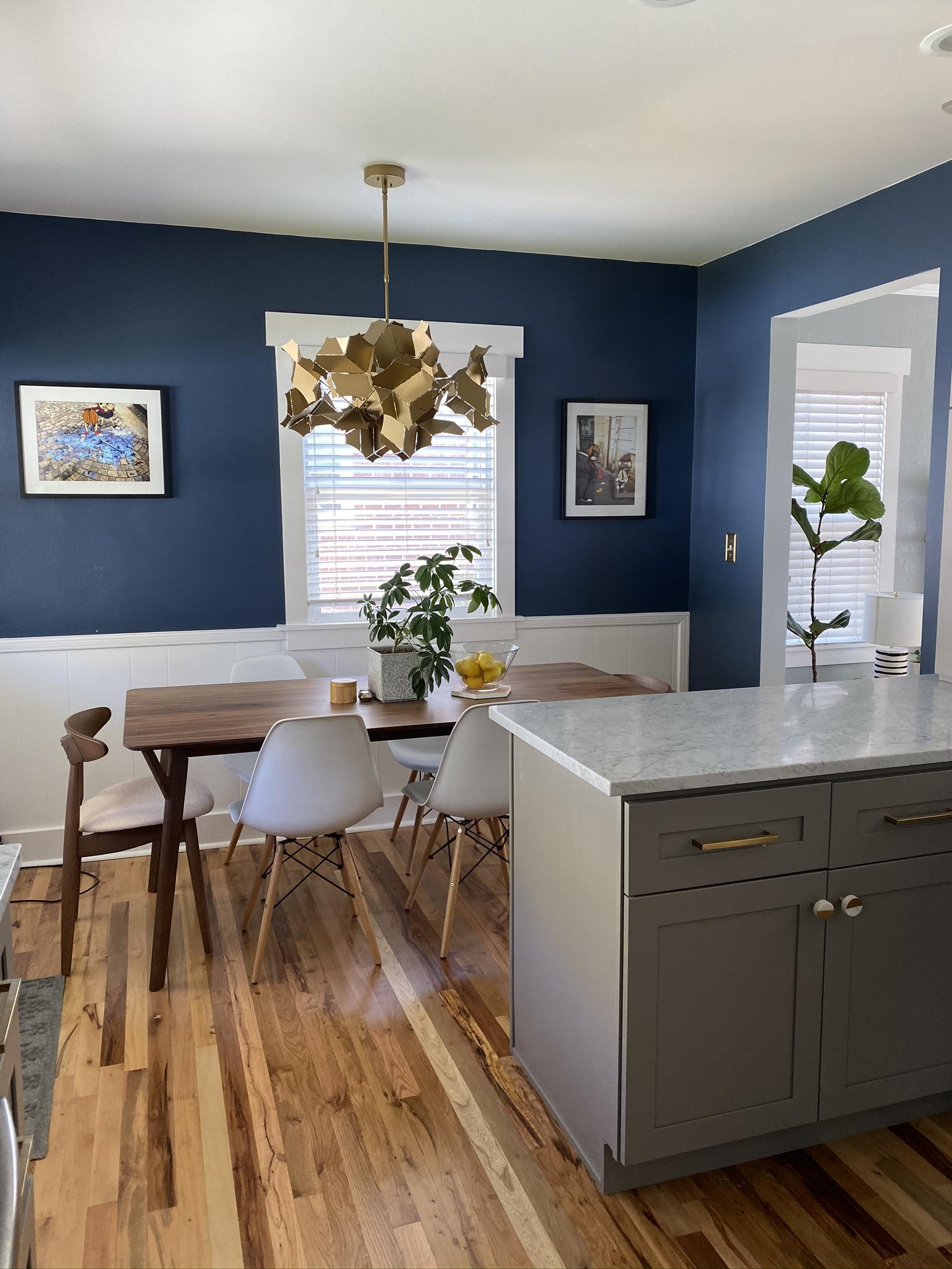 A kitchen with blue walls and wooden floors