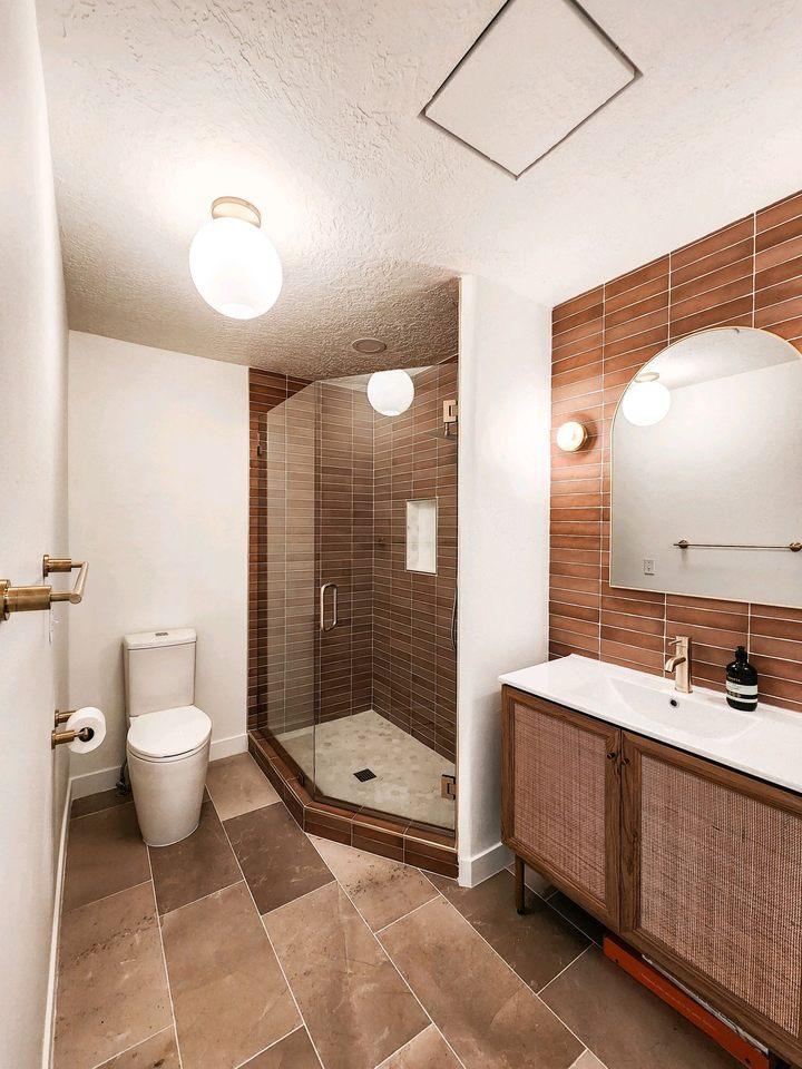 A bathroom with a walk in shower next to a toilet