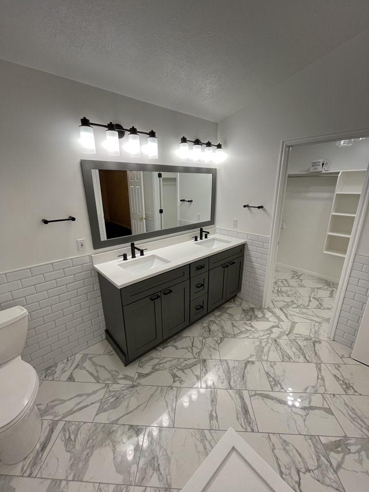 A bathroom with a marble floor and white walls