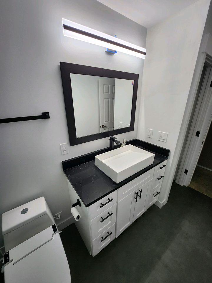 A bathroom with a sink, toilet and mirror